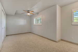 Unfurnished bedroom with multiple windows, carpet, baseboards, and a textured ceiling