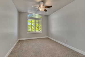 Carpeted spare room featuring a textured ceiling, a ceiling fan, baseboards, and lofted ceiling