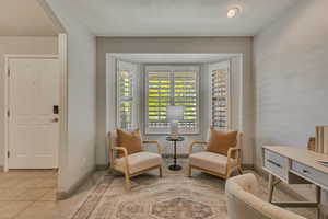 Sitting room with arched walkways, baseboards, and light tile patterned floors