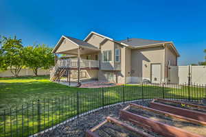 Rear view of house featuring a vegetable garden, stairway, a patio, and a wooden deck