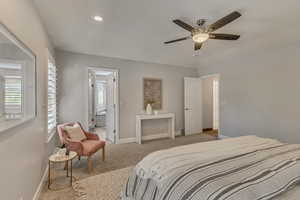 Carpeted bedroom with baseboards, ensuite bathroom, ceiling fan, and recessed lighting