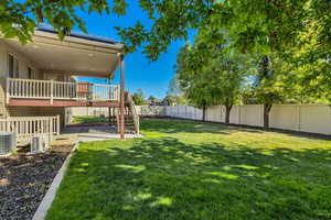 View of yard with central air condition unit, a patio, and a deck