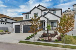 View of front of home featuring board and batten siding, fence, driveway, a garage, and a porch