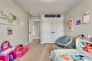 Carpeted bedroom featuring baseboards and a closet