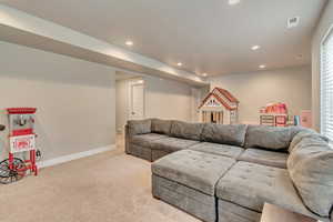 Living area with carpet flooring, recessed lighting, and baseboards