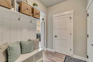 Mudroom with light wood-type flooring and baseboards