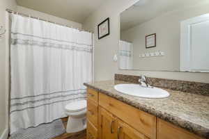 Full bath featuring wood finished floors, toilet, and vanity