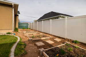 View of yard with a garden and fence