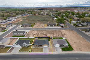 Aerial view of residential area with property parcel outlined and a mountainous background