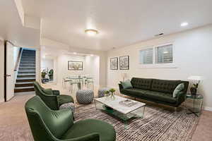 VIRTUALLY STAGED DOWNSTAIRS LIVING ROOM featuring stairway, light colored carpet, and recessed lighting