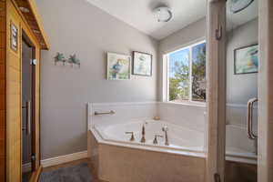 Upstairs Primary Suite -Full bathroom with a bath and vaulted ceiling
