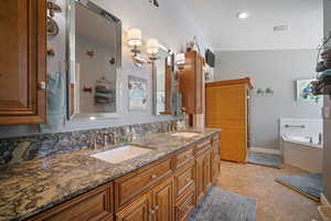 Upstairs Primary Suite Bathroom featuring double vanity and a garden tub
