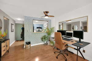 Office with ceiling fan, baseboards, light wood-style floors, and wallpapered walls