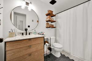 Full bath featuring toilet, vanity, tile patterned floors, and a shower with shower curtain