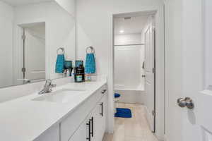Bathroom with tile patterned floors, vanity, toilet, and  shower combination