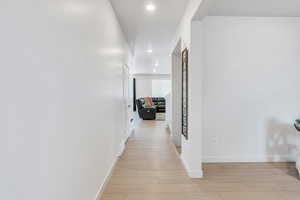 Hall featuring light wood-style floors, recessed lighting, and baseboards