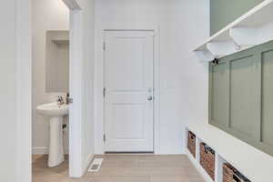 Mudroom featuring a sink and baseboards