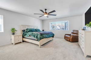 Bedroom featuring light carpet, baseboards, and ceiling fan