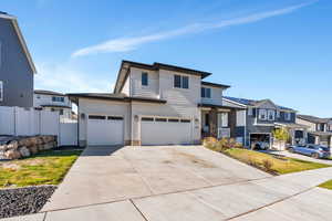 View of front of home with fence, driveway, a residential view, and an attached garage