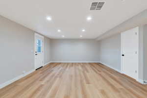 Spare room with recessed lighting, baseboards, and light wood-type flooring