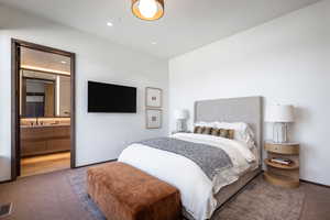 Carpeted bedroom featuring recessed lighting, connected bathroom, and baseboards