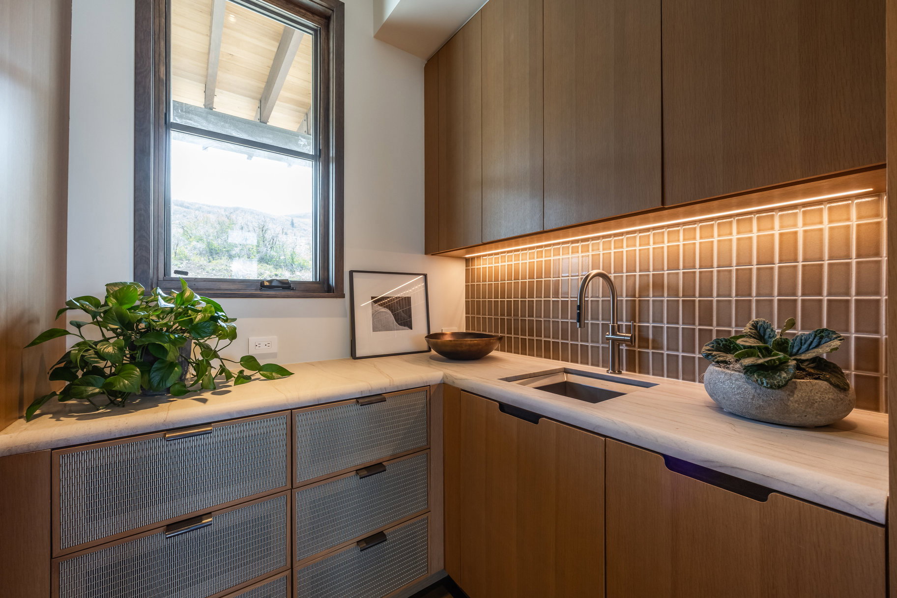 Kitchen featuring a sink, decorative backsplash, and light countertops