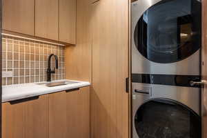 Washroom featuring stacked washing machine and dryer