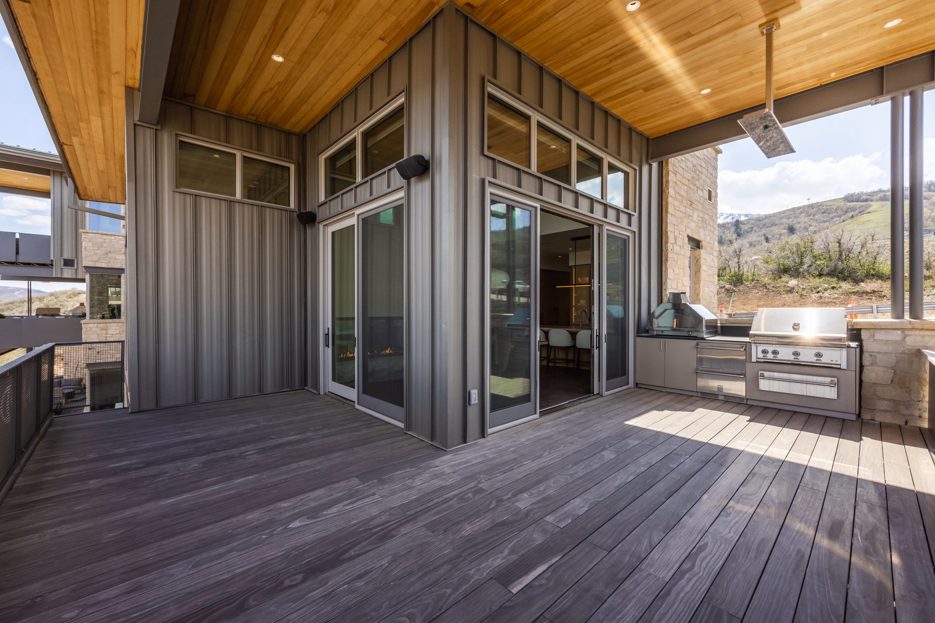 Wooden terrace with exterior kitchen, area for grilling, and a mountain view