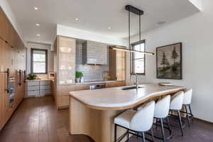 Kitchen featuring a sink, modern cabinets, a kitchen breakfast bar, and recessed lighting