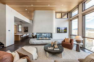 Living room featuring wooden ceiling, wood finished floors, recessed lighting, and a multi sided fireplace