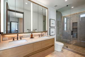 Full bath featuring toilet, a stall shower, double vanity, and recessed lighting