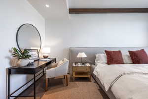 Bedroom with carpet floors, beam ceiling, and recessed lighting