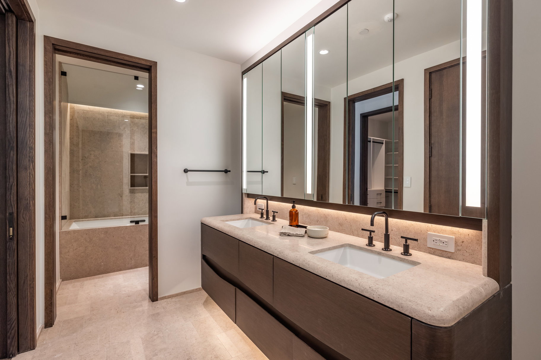 Bathroom featuring a bathtub, double vanity, and recessed lighting