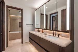 Bathroom featuring a bathtub, double vanity, and recessed lighting