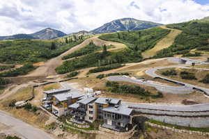 Aerial view of property and surrounding area featuring a mountainous background