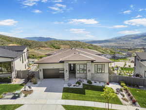 View of front of house featuring a garage, a mountain view, concrete driveway, roof with shingles, and a gate