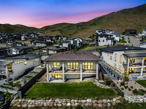 Back of house at dusk with a mountain view, a residential view, and a fenced backyard
