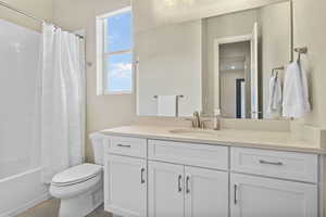 Full bath featuring toilet, vanity, and shower / bath combo