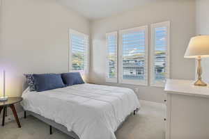 Bedroom featuring light colored carpet and baseboards