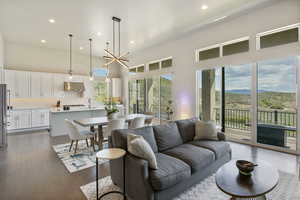 Living area featuring a towering ceiling, recessed lighting, dark wood finished floors, mountains and valley view