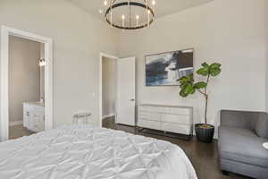 Bedroom featuring a chandelier, baseboards, ensuite bathroom, a sink, and wood finished floors
