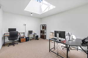 Carpeted office with a skylight
