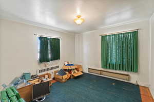 Bedroom with baseboard heating and radiator heating unit