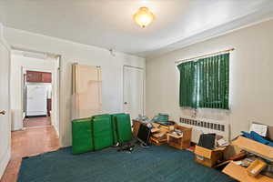 Bedroom with radiator heating unit and carpet floors