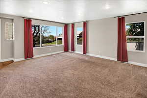 Spare room featuring carpet flooring, baseboards, recessed lighting, and a textured ceiling