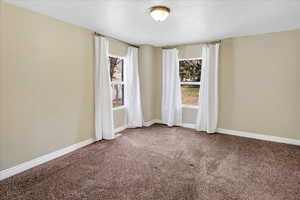 Empty room featuring carpet floors and baseboards