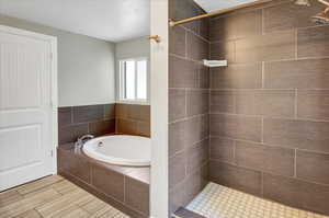 Full bathroom featuring a tile shower and a bath