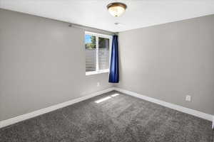 Carpeted spare room with baseboards