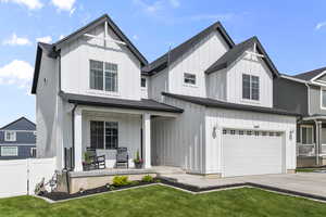 Modern farmhouse with a porch, board and batten siding, an attached garage, and concrete driveway