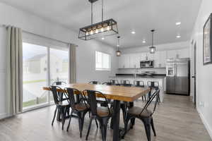 Dining room featuring recessed lighting, light wood-style flooring, and baseboards